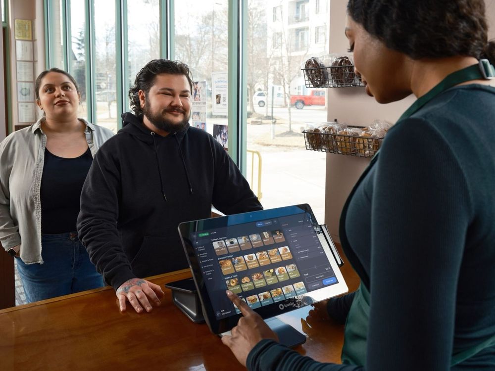 A customer using a clean tablet point-of-sale system at a café counter