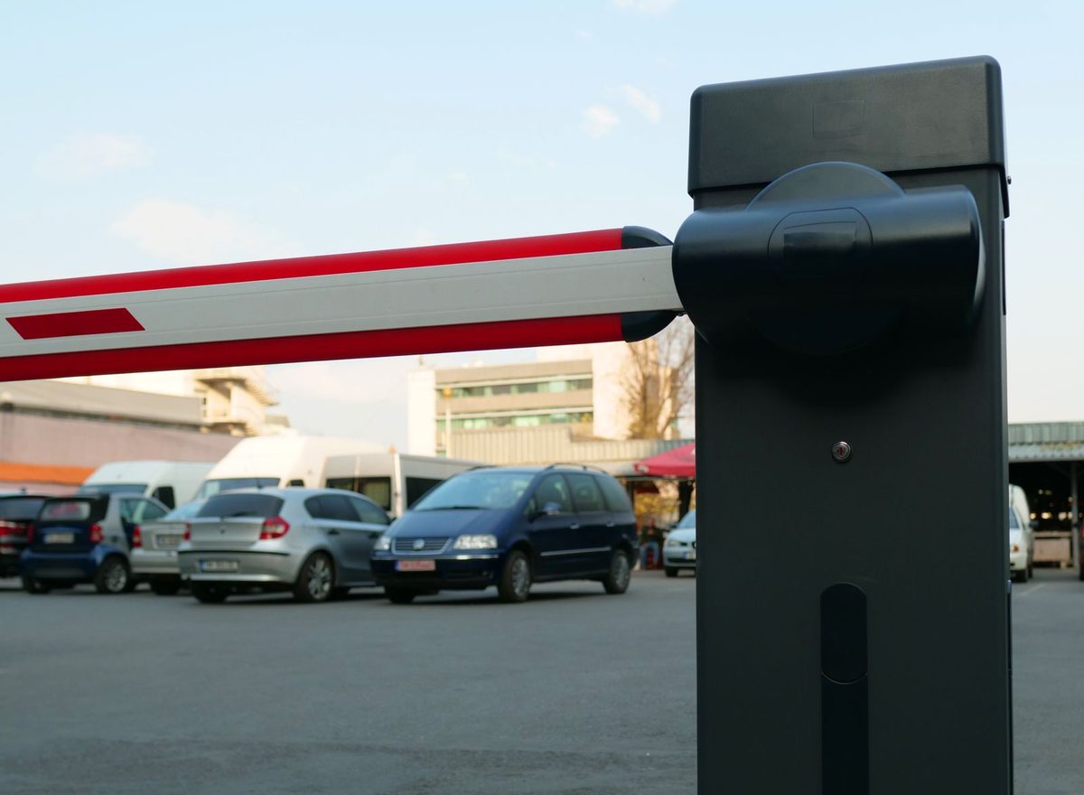 A boom barrier raised at the entrance to a parking area