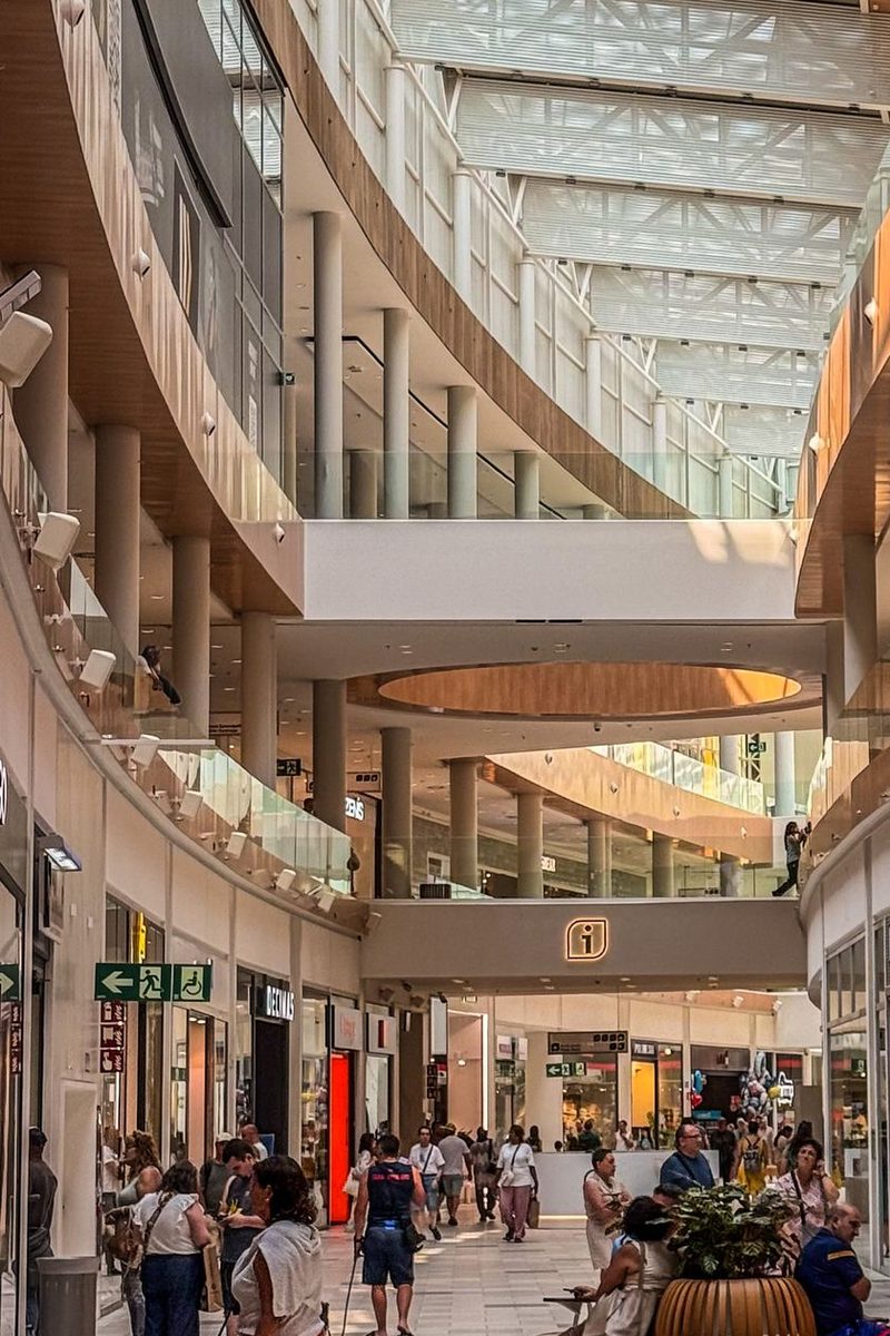 Shoppers walking through the concourse of a busy shopping centre